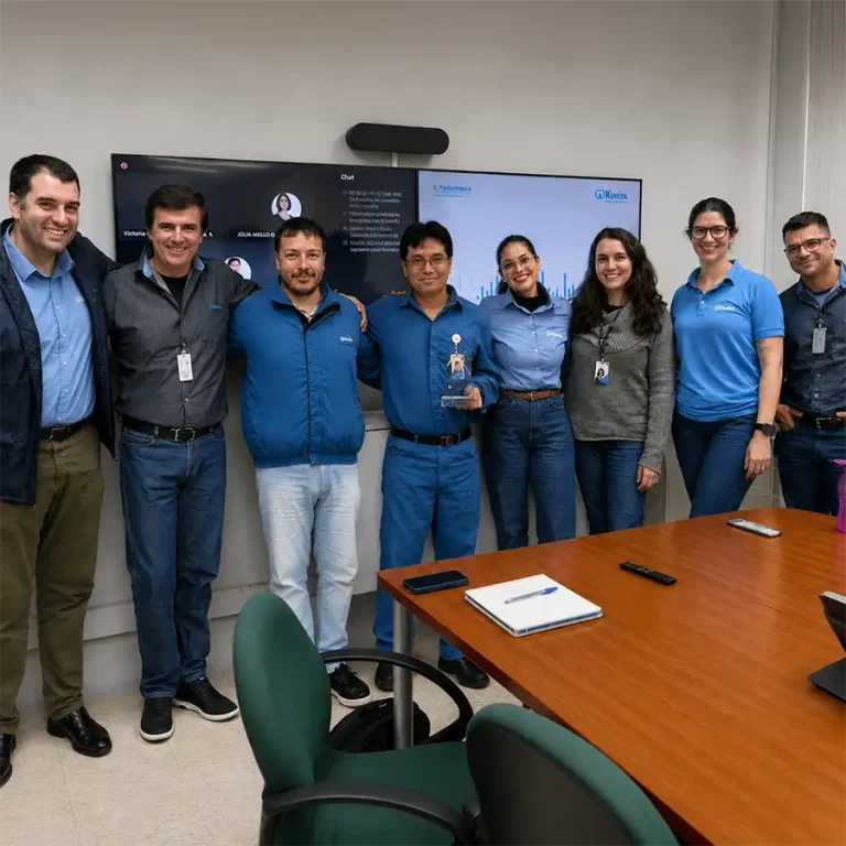 Equipes da Kurita e da Braskem PP4 reunidas em sala de reunião, com um troféu ao centro